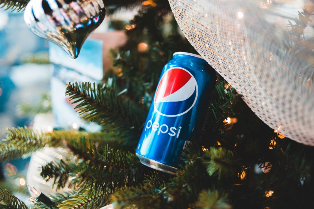 pexels-photo-6150571-6150571 Pepsi can nestled in a Christmas tree with festive ornaments and lights.